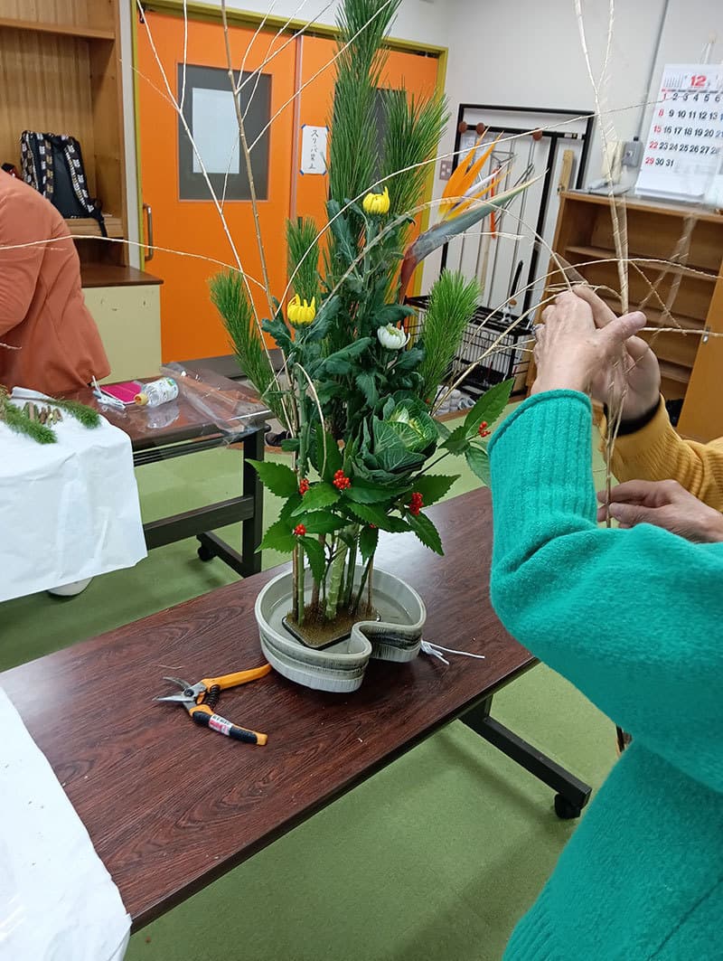 長机の上で大きな生け込みをしている写真