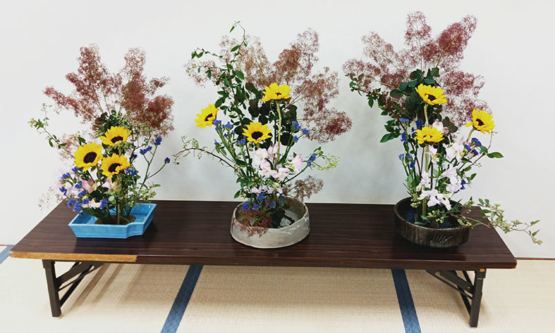 華やかな生け花が3台並んでいる写真です。