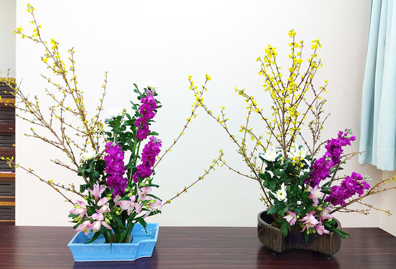 黄色のれんぎょうとピンクや紫のコントラストが綺麗な生け花の写真です