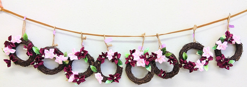 桜が添えられた小さいリースが８つ並んでいる写真です